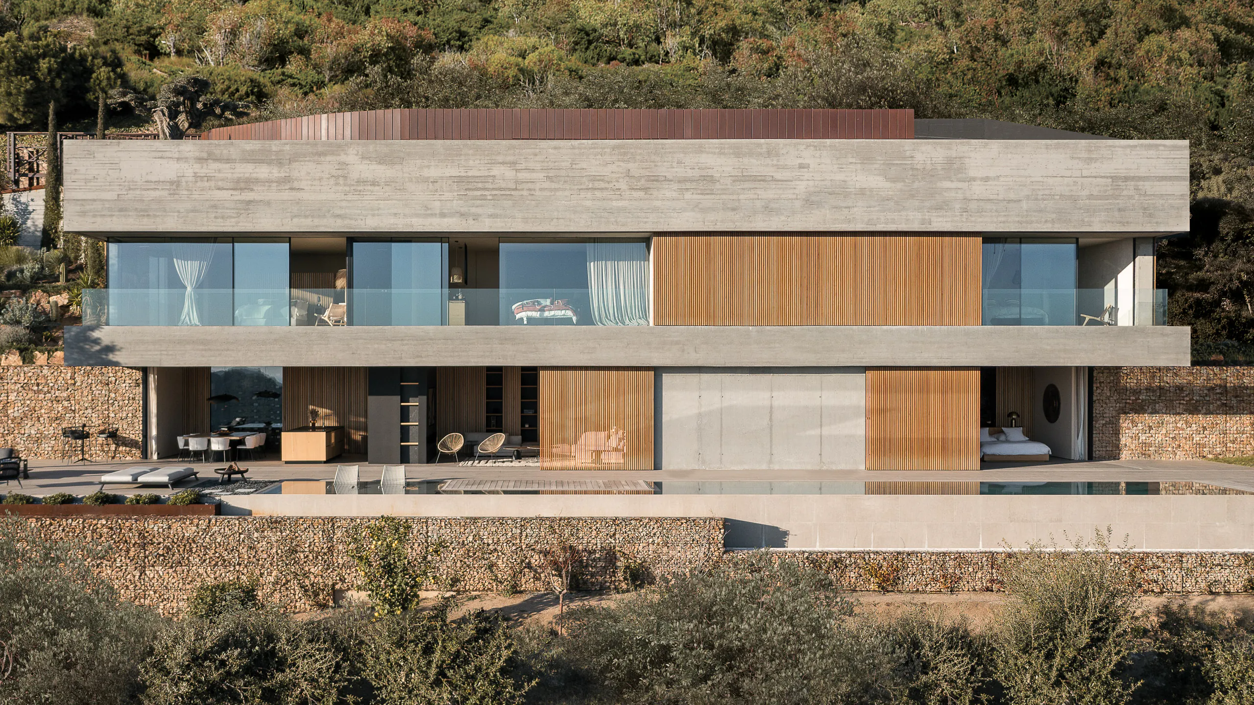 Contemporary hillside residence shaped by glass timber and stone