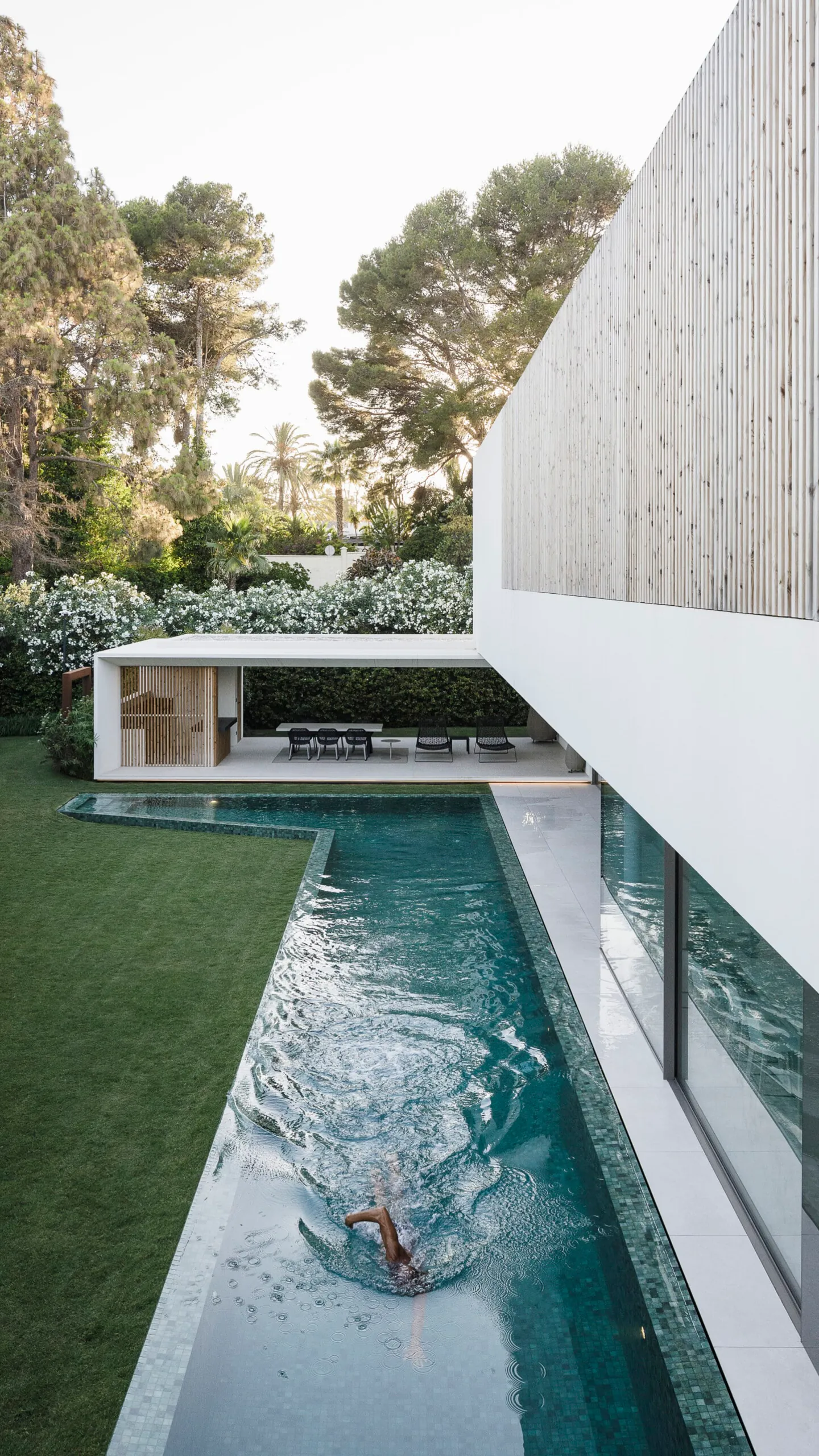 White courtyard residence arranged around water and greenery