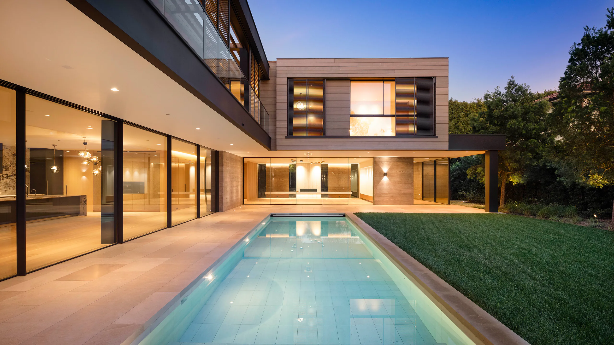 Generous glazed openings arranged around a pool courtyard
